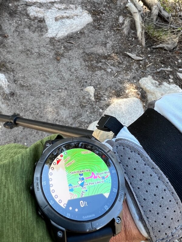 Garmin smartwatch displaying a preloaded GPX trail map with waypoints along the Mount Whitney route, paired with a Garmin InReach Mini 2 for route notifications and distance to key points.