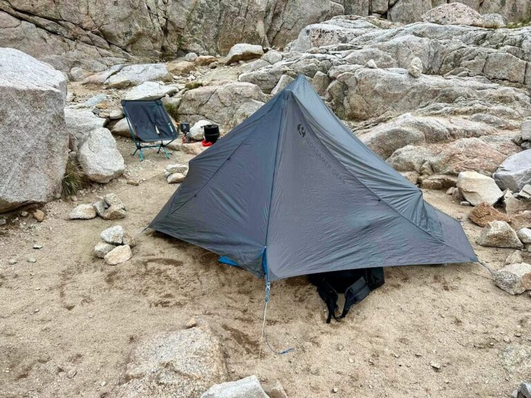 Gossamer Gear The One ultralight silnylon tent set up at Trail Camp on Mount Whitney, with a Helinox Zero chair, Jetboil Stash cook system, and a lightweight bear-resistant food canister in the background.