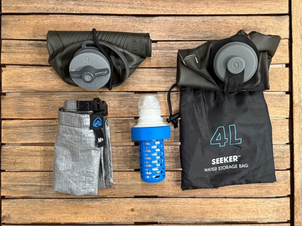 The best backpacking water filter setup: Katadyn BeFree filter, HydraPak Flux 1L bottle, HydraPak Seeker 4L water storage bottle, and Zpacks Dyneema Medium Dry Bag.